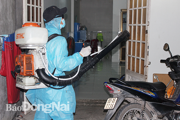 Nhân viên y tế phun thuốc diệt muỗi trong khu dân cư.