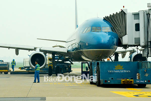Máy bay của hãng hàng không Vietnam Airlines đón khách tại Cảng hàng không quốc tế Tân Sơn Nhất. Ảnh: K.GIỚI