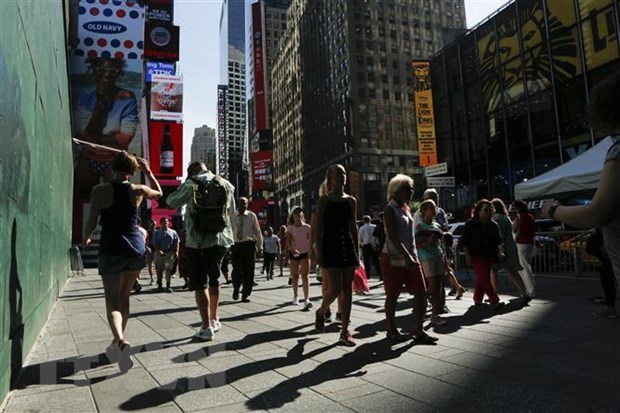 Người dân đi bộ trên Quảng trường Thời Đại ở New York , Mỹ, trong ngày nắng nóng. (Ảnh: AFP/TTXVN)