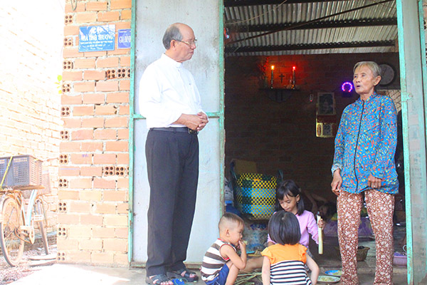 Linh mục Nguyễn Ngọc Lâm (bìa trái), Chánh xứ Giáo xứ Phú Lý (huyện Vĩnh Cửu) thăm hỏi, giúp đỡ những người nghèo ở các căn nhà tình thương của giáo xứ