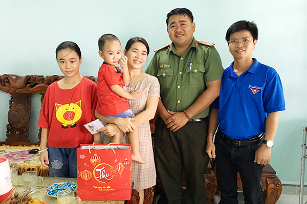 Đại úy Huỳnh Minh Đức, Phó Bí thư Đoàn Công an tỉnh (thứ 2 từ phải qua) thăm hỏi và tặng quà gia đình chị Trương Thị Luyến (vợ Trung úy Hoàng Văn Huê), đang công tác tại Đảo Sơn Ca.