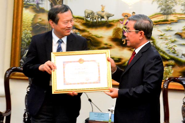 Phó chủ tịch UBND tỉnh Nguyễn Quốc Hùng (bên phải) trao Bằng khen cho Bệnh viện Vinh Dân.