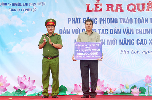 Thượng tá Nguyễn Hồng Sơn, Trưởng Công an huyện Tân Phú trao bảng tượng trưng cho UBND xã Phú Lộc để thực hiện công tác dân vận