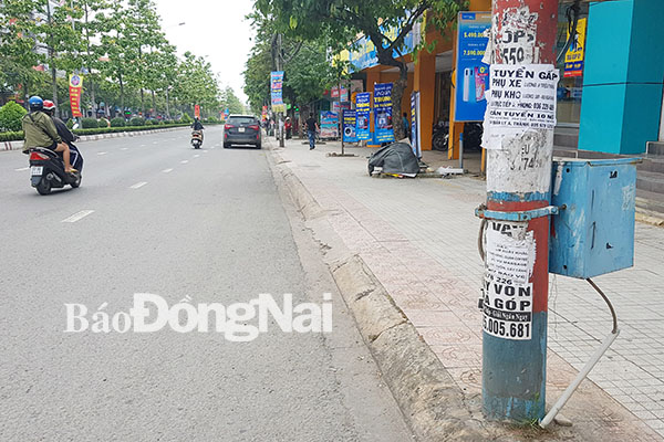 Một trụ điện khác khá nham nhở bởi những tờ rơi quảng cáo trên đường Đồng Khởi (TP.Biên Hòa). Ảnh: L.Phương