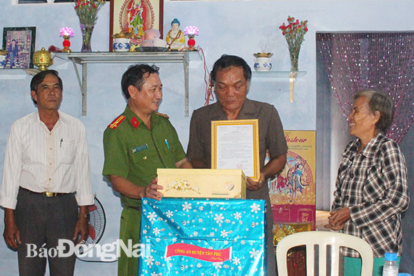 Thượng tá Nguyễn Hồng Sơn (thứ 2 từ trái qua), Trưởng Công an huyện Tân Phú trao nhà tình thương cho một hộ nghèo tại xã Phú Lộc
