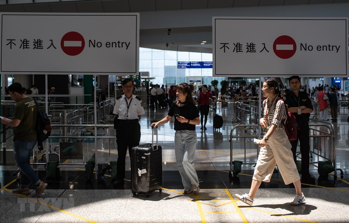 Hành khách làm thủ tục tại sân bay quốc tế Hong Kong ngày 14-8. (Ảnh: AFP/TTXVN)