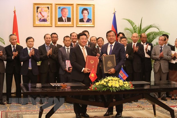  Phó Thủ tướng, Bộ trưởng Ngoại giao Phạm Bình Minh và Phó Thủ tướng, Bộ trưởng Bộ Ngoại giao và Hợp tác quốc tế Campuchia Prak Sokhonn ký kết văn kiện của Kỳ họp. (Ảnh: Trần Long/TTXVN)