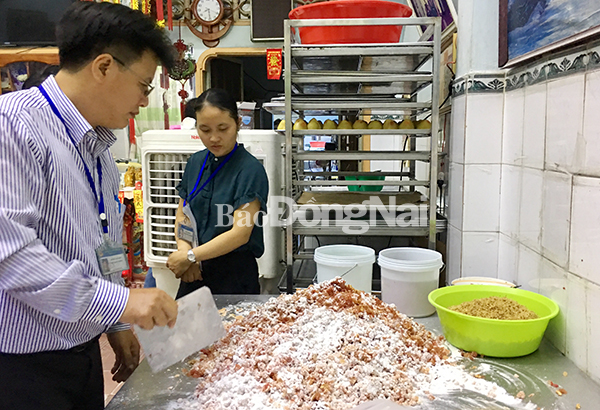 Ông Lê Minh Hân, Phó Chi cục trưởng Chi cục phát triển nông thôn và Quảng lý chất lượng nông lâm thủy sản đang kiểm tra bánh tại cơ sở Dụ Thành