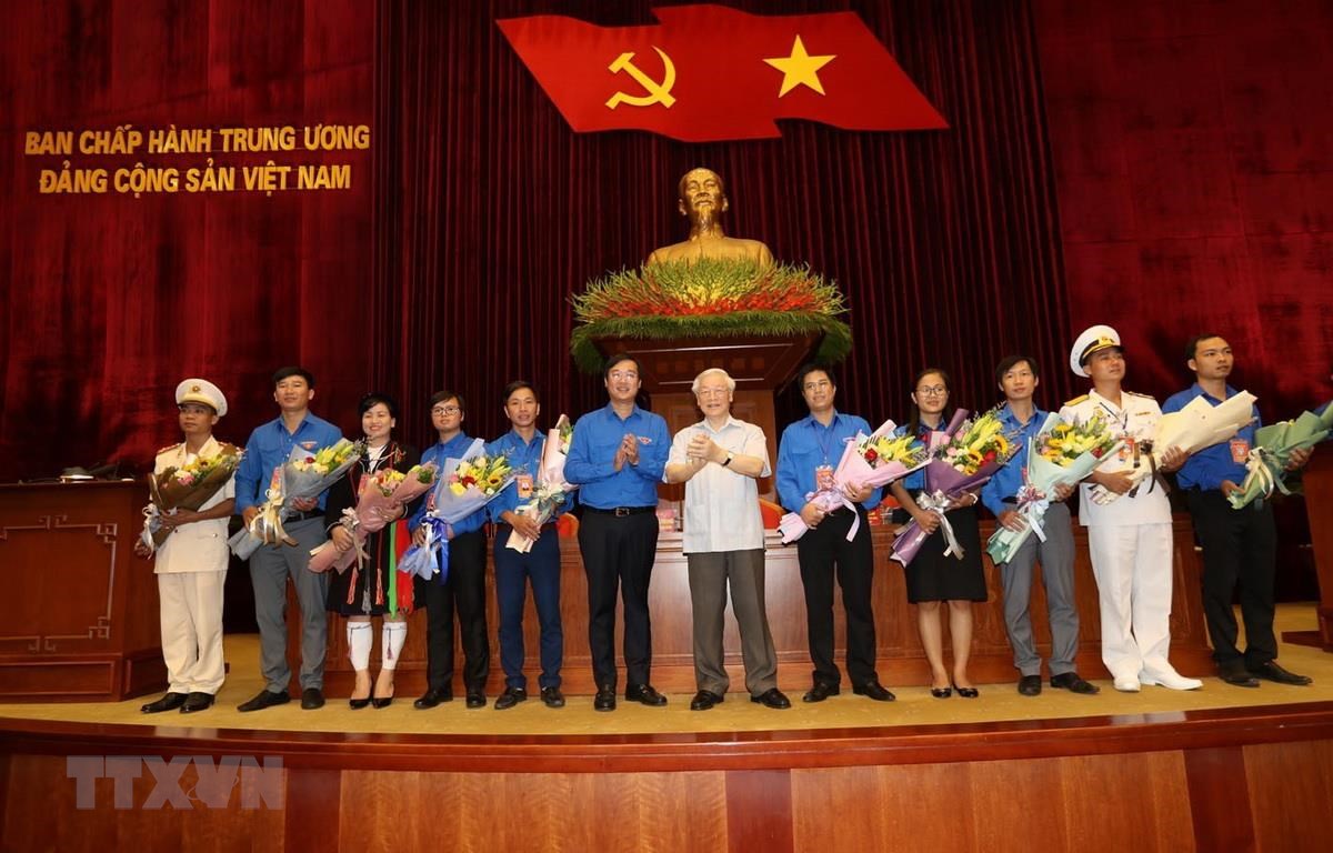 Tổng Bí thư, Chủ tịch nước Nguyễn Phú Trọng tặng hoa các đảng viên trẻ tiêu biểu. (Ảnh: Trí Dũng/TTXVN)