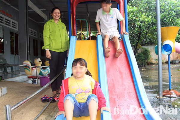Cô bảo mẫu Trần Thị Nga hướng dẫn học viên vui chơi tại Trung tâm điều dưỡng phục hồi chức năng nạn nhân chất độc da cam và trẻ em bất hạnh huyện Định Quán