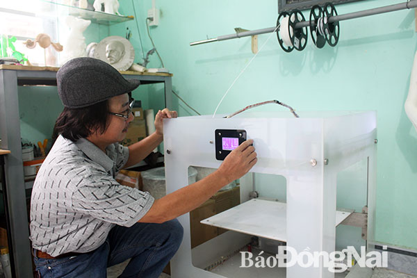 Nghệ sĩ Phạm Văn Út thực hiện các thao tác trên máy in 3D AK. Ảnh: MY NY
