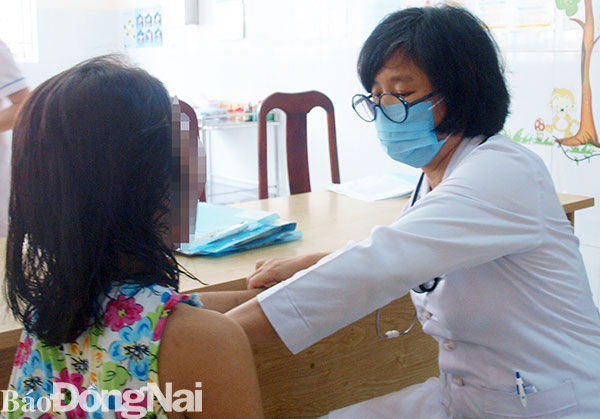 Một bé gái nhiễm HIV khám bệnh về hô hấp tại Bệnh viện Nhi đồng Đồng Nai. Ảnh: C.Ly
