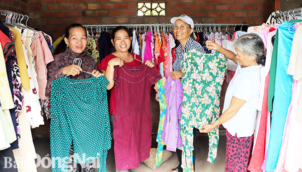 Chủ tịch Hội Liên hiệp phụ nữ xã Hưng Lộc (huyện Thống Nhất) Nguyễn Thị Kim Chung (thứ 2 từ trái sang) giúp người dân lựa quần áo tại Shop 0 đồng