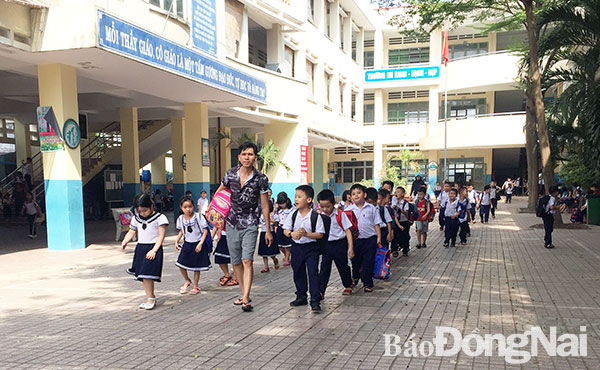 Người nhà của giáo viên Trường tiểu học Phan Đình Phùng (phường Long Bình, TP.Biên Hòa) hướng dẫn học sinh lên xe ra về nhà cô giáo theo mô hình bán trú