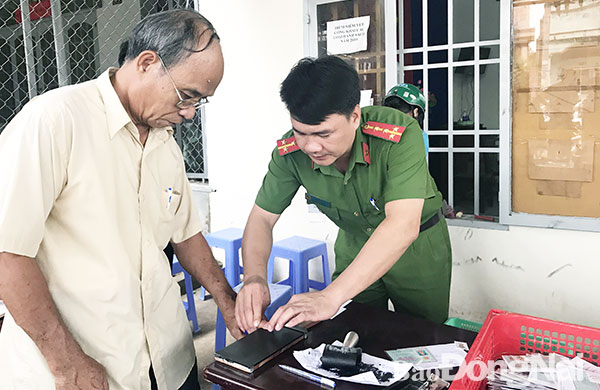 Cán bộ Phòng Cảnh sát quản lý hành chính về trật tự xã hội Công an tỉnh lăn tay cấp mới CMND cho người  dân phường Bảo Vinh (TP.Long Khánh). Ảnh: K. Liễu