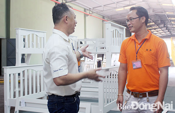 Công nhân Trần Quốc Vĩnh (phải, Công ty cổ phần Johnson Wood, Khu công nghiệp Tam Phước, TP.Biên Hòa) có thể giao tiếp cơ bản tiếng Hoa với cấp quản lý người nước ngoài