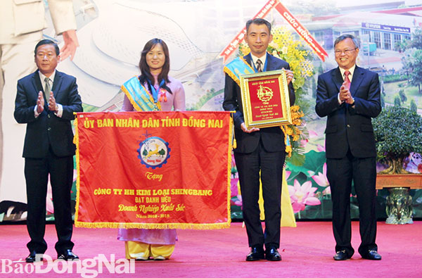 Chủ tịch UBND tỉnh Cao Tiến Dũng và Chủ tịch Ủy ban MTTQ tỉnh Đào Văn Phước tặng cờ và bằng khen doanh nghiệp xuất sắc cho Công ty hữu hạn kim loại Shengbang ở Khu công nghiệp Sông Mây (huyện Trảng Bom)