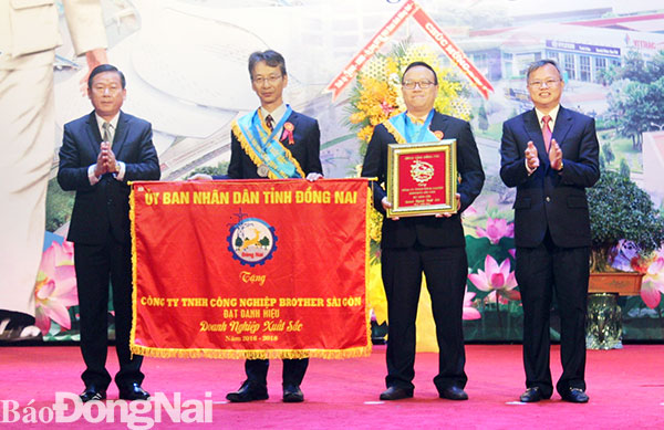Chủ tịch UBND tỉnh Cao Tiến Dũng và Chủ tịch Ủy ban MTTQ tỉnh Đào Văn Phước tặng cờ và bằng khen doanh nghiệp xuất sắc cho Công ty TNHH công nghiệp Brother Sài Gòn