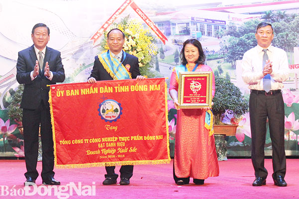Phó bí thư Thường trực Tỉnh ủy Hồ Thanh Sơn và Chủ tịch Ủy ban MTTQ tỉnh Đào Văn Phước tặng cờ và bằng khen doanh nghiệp xuất sắc cho Tổng công ty Công nghiệp thực phẩm Đồng Nai