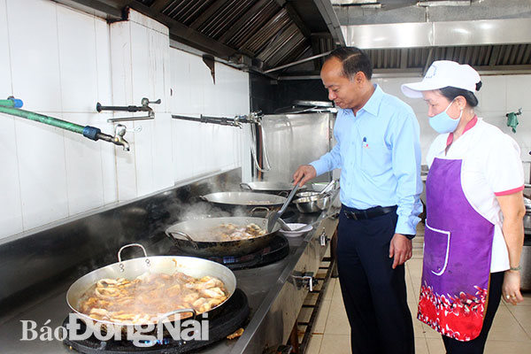 Tổng giám đốc Tổng công ty Dofico Nguyễn Hữu Hiểu thăm khu nhà bếp, dặn dò nhân viên nhà bếp chế biến nhiều món ngon, hợp khẩu vị của người lao động. Ảnh: H.Dung