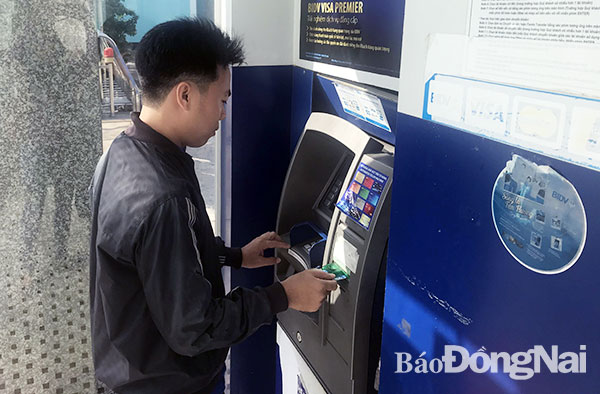 Các máy ATM cần được trang bị thiết bị chống sao chép, trộm cắp thông tin thẻ. Trong ảnh: Khách hàng thực hiện giao dịch rút tiền tại trụ ATM trên đường Hà Huy Giáp (phường Quyết Thắng, TP.Biên Hòa)