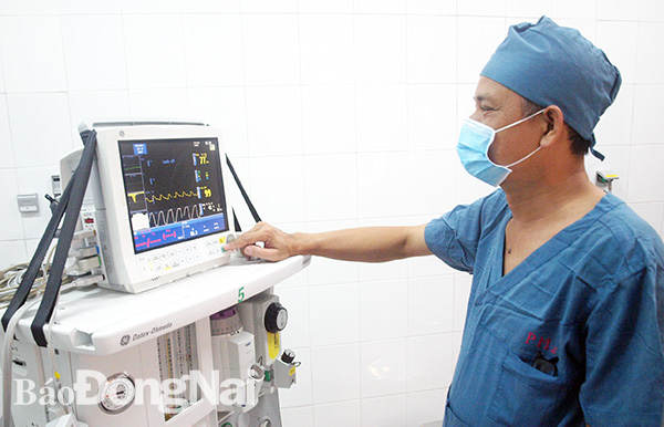Một bác sĩ gây mê đang kiểm tra chỉ số sinh tồn cho bệnh nhi trong ca mổ tại Bệnh viện nhi đồng Đồng Nai. Ảnh: B.Nhàn