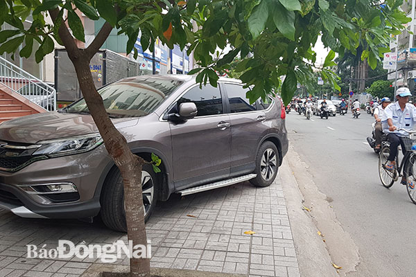 Một ô tô đậu chiếm hết vỉa hè dành cho người đi bộ trên đường Cách Mạng Tháng Tám (TP.Biên Hòa)
