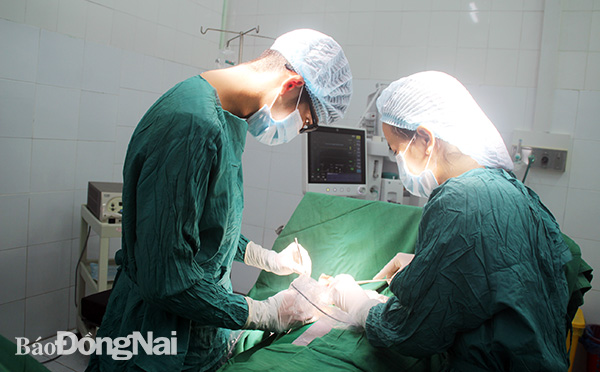 Các bác sĩ chuẩn bị mổ khối u mỡ cho một bệnh nhân tại Trung tâm y tế huyện Nhơn Trạch. Ảnh: B. Nhàn