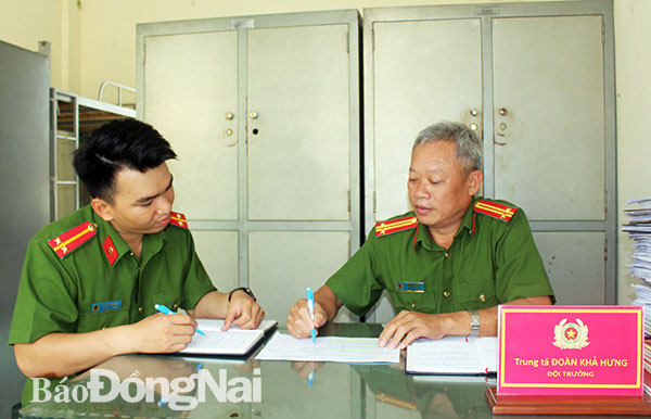 Trung tá Đoàn Khả Hưng (phải), Đội trưởng Đội Điều tra tổng hợp Công an huyện Thống Nhất bàn phương án điều tra vụ án với một cán bộ trong đội. Ảnh: T.Tâm