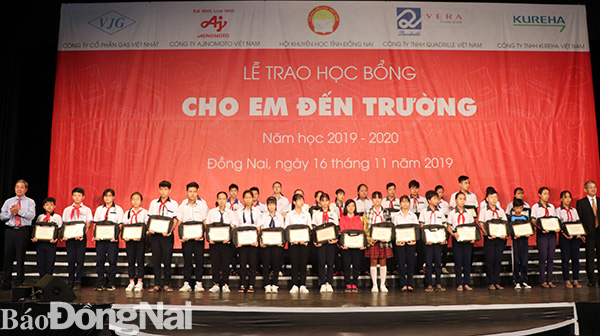 Phó chủ tịch UBND tỉnh Nguyễn Quốc Hùng (bên trái) và ông Keiji Kaneko (Tổng giám đốc Công ty Ajinomoto Việt Nam) trao quà, học bổng cho học sinh