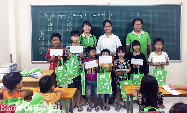  Đại diện Trung tâm Ngoại ngữ Biên Hòa, cô giáo Nguyễn Thị Lệ Thu (đứng giữa) cùng các em học sinh được nhận học bổng