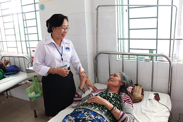 Chị Nguyễn Thị Ánh Tuyết, Trưởng phòng Điều dưỡng Trung tâm y tế huyện Vĩnh Cửu thăm hỏi bệnh nhân đang điều trị tại trung tâm. Ảnh: K.NGỌC