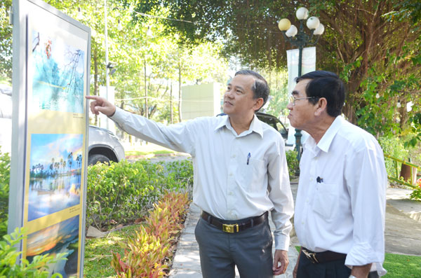Phó trưởng ban Tuyên giáo Tỉnh ủy Phạm Tấn Linh xem triển lãm ảnh tại buổi họp mặt