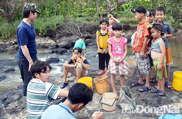 Người lớn và trẻ em tập trung ra suối Đá (xã Thanh Sơn, huyện Định Quán) chuẩn bị đi bắt cua. Ảnh: N.An