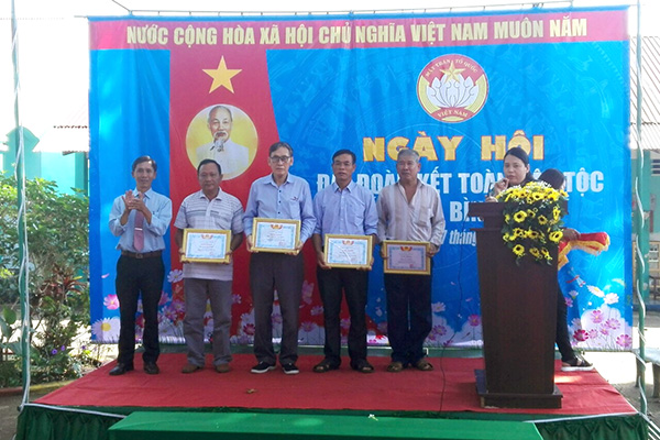 Trưởng khối vận xã Bình Lộc (TP.Long Khánh) Phạm Thanh Xuân (bìa trái) khen thưởng các ấp có thành tích tốt trong xây dựng khối đại đoàn kết toàn dân tộc năm 2019. Ảnh:N.Trinh