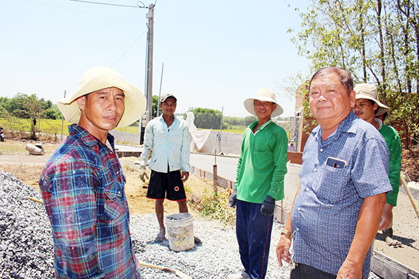 Ông Phan Văn Bảy (phải) kiểm tra công tác thi công đường nông thôn ở tổ 7