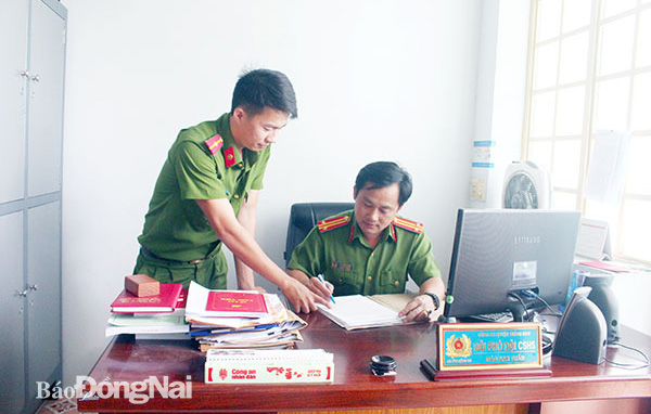 Trung tá Đào Anh Tuấn (phải), Đội phó Đội Cảnh sát hình sự Công an huyện Trảng Bom trao đổi nghiệp vụ với cán bộ đội về các vụ án. Ảnh: T.Tâm