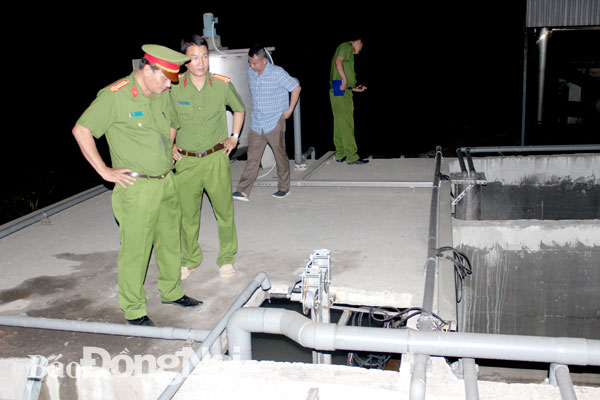 Thượng tá Lương Đại Thủy (bìa trái), Trưởng phòng Cảnh sát phòng chống tội phạm về môi trường trực tiếp kiểm tra hệ thống xử lý nước thải của Công ty Thương Phúc (huyện Long Thành) vào tối 18, rạng sáng 19-12. Ảnh: T.Danh