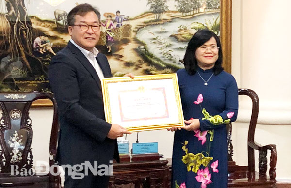 Phó chủ tịch UBND tỉnh Nguyễn Hòa Hiệp (phải) trao bằng khen của UBND tỉnh cho ông Kim Byoung Bum