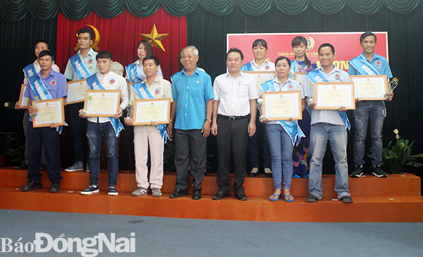 Chị Vũ Thị Kết (hàng sau, thứ ba từ phải qua) cùng đồng nghiệp nhận giấy khen đoàn viên Công đoàn tiêu biểu năm 2018 của Công đoàn khu công nghiệp Biên Hòa