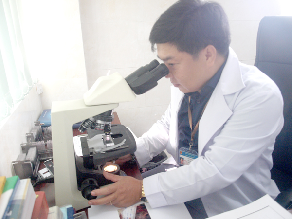 Bác sĩ Nguyễn Gió soi mẫu vật dưới kính hiển vi