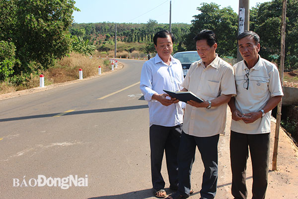 Ông Nguyễn Văn Năm (bìa phải) cùng với các hộ dân Đồi 57 bên tuyến đường mới mở do nông dân hiến đất. Ảnh:B.Mai