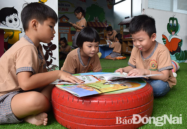 Học sinh lớp lá Trường mầm non Trảng Dài (phường Trảng Dài, TP.Biên Hòa) xem sách tại thư viện. Ảnh: H.Yến