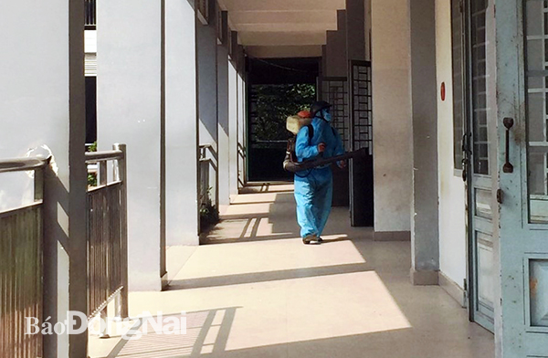 Nhân viên Trường THCS Tam Phước (TP.Biên Hòa) phun dịch sát trùng trường lớp phục vụ học sinh chuẩn bị trở lại trường. Ảnh: C.Nghĩa