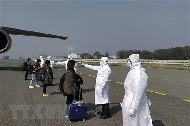 Kiểm tra thân nhiệt những hành khách trở về từ Vũ Hán, Trung Quốc. (Ảnh minh họa. AFP/TTXVN)