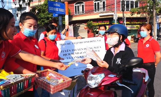 Cán bộ, nhân viên Hội Chữ thập đỏ tặng khẩu trang y tế và hướng dẫn cách đeo khẩu trang đúng cách cho người đi đường.	