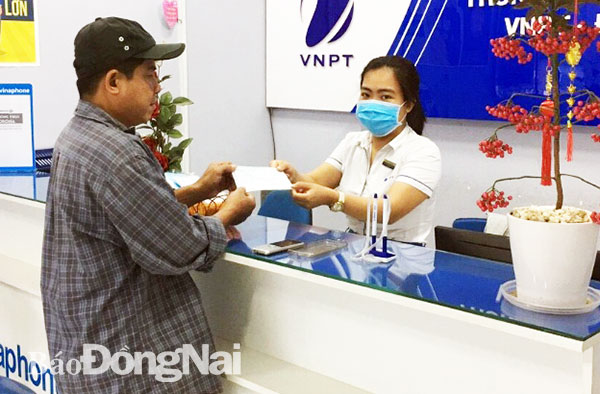Nhân viên Trung tâm kinh doanh VNPT phát khẩu trang cho khách đến giao dịch