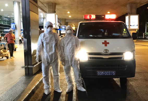 Nhân viên y tế cùng xe cấp cứu của Trung tâm y tế huyện Trảng Bom đón người dân tại Sân bay Tân Sơn Nhất từ Trung Quốc vào tối 7-2.