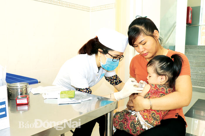 Nhân viên y tế tiêm chủng vắc-xin ngừa bệnh cho trẻ tại Trung tâm Kiểm soát bệnh tật tỉnh Ảnh: HẠNH DUNG