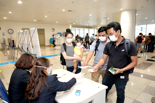 Hành khách làm thủ tục khai báo y tế trước khi nhập cảnh vào Việt Nam tại cửa khẩu sân bay quốc tế Nội Bài (Hà Nội), chiều 7-3 Ảnh: TTXVN
